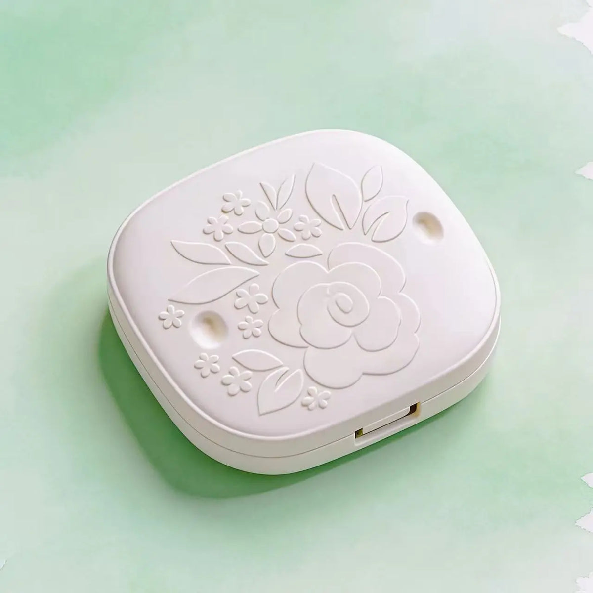 Morong white powder compact box with rounded corners, made from molded sugarcane pulp. Features a detailed, centered floral embossed pattern with leaves and smaller blossoms, showcasing its natural fiber texture and premium, plastic-free design for clean beauty brands.