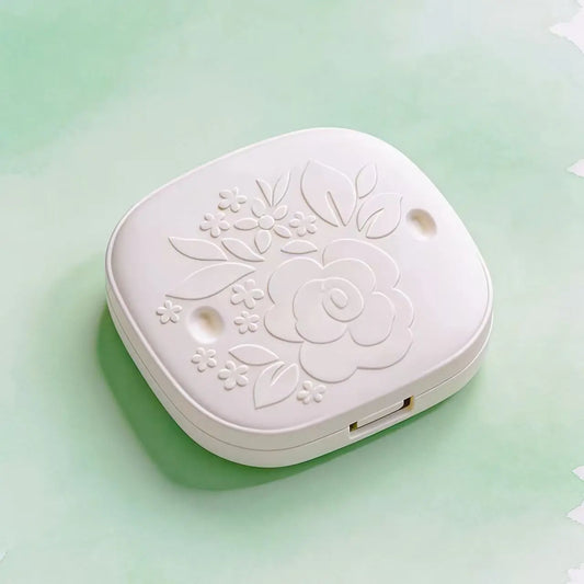 Morong white powder compact box with rounded corners, made from molded sugarcane pulp. Features a detailed, centered floral embossed pattern with leaves and smaller blossoms, showcasing its natural fiber texture and premium, plastic-free design for clean beauty brands.